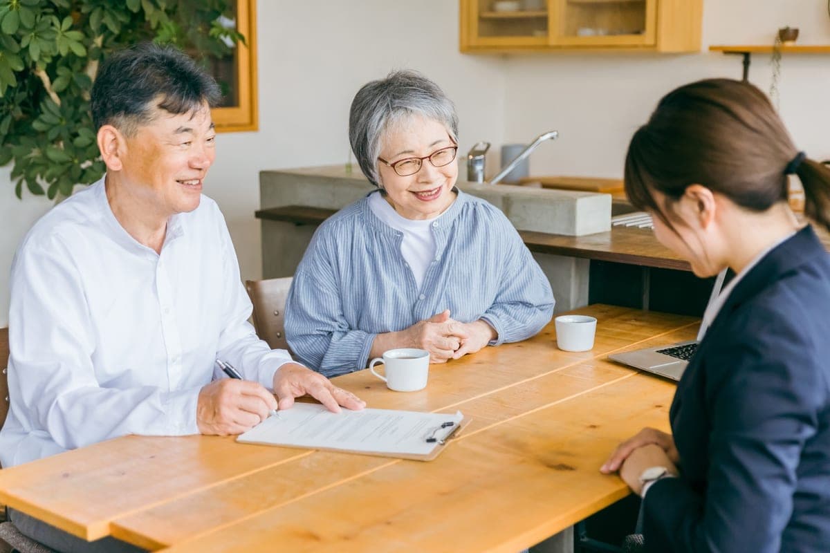 書類に記入しながらスタッフと話すご夫婦(事前相談の様子)